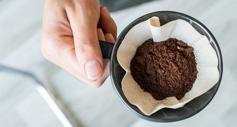A mug with coffee grounds inside a coffee filter.